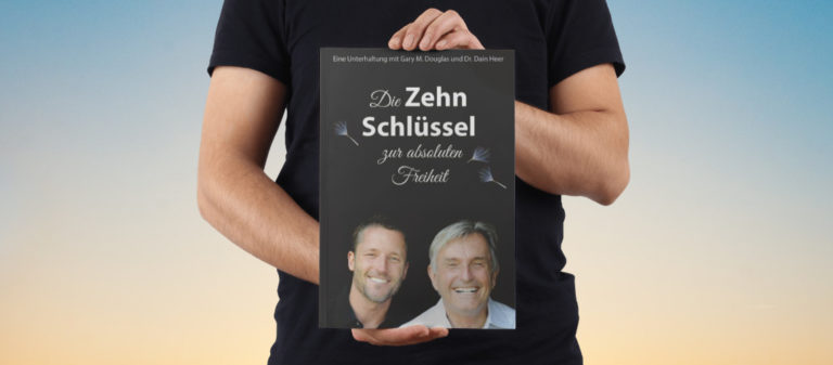 Person hält Buch über Freiheit und Harmonie gegen Himmel im Hintergrund.