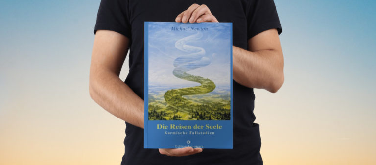 Person hält Buch "Die Reisen der Seele" vor Himmelshintergrund.