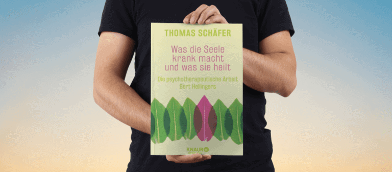 Person hält Buch "Was die Seele krank macht" von Thomas Schäfer gegen Handystrahlung.