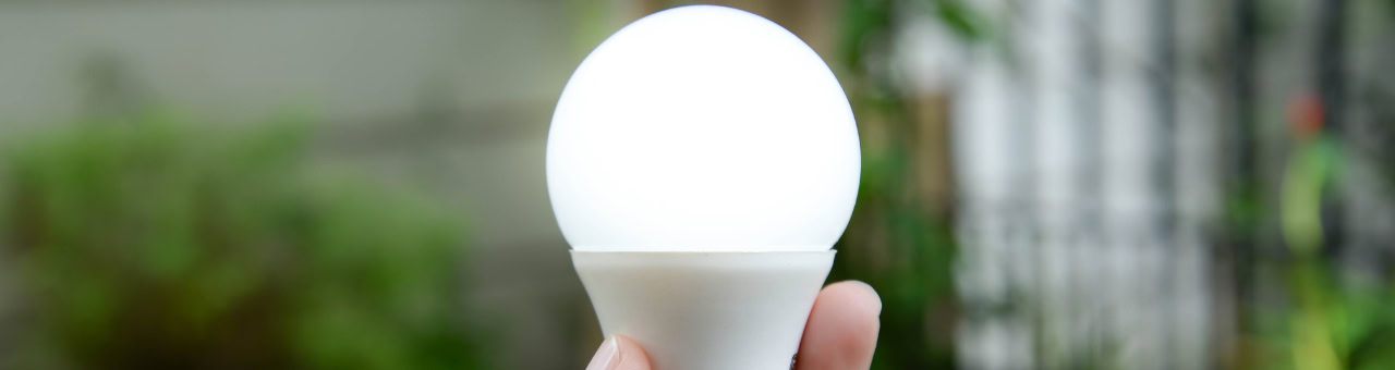 Glühbirne in der Hand, symbolisiert Beleuchtung und Energie.