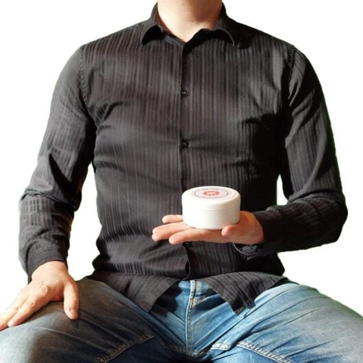 Geopat-Groesse-gross-schraeg Cooler Typ hält eine Plastikdose in der Hand