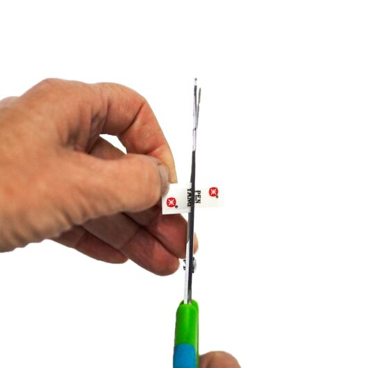 headset-sticker-halbieren Hand mit Schere zerschneidet Aufkleber